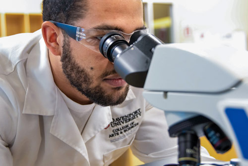 A student looking through a microscope